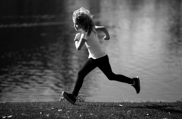 Niño niño corriendo al aire libre niño corriendo en un parque de verano corriendo por la mañana