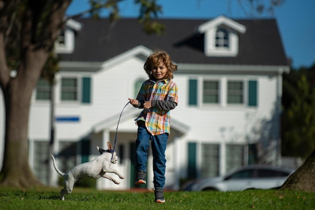 Niño niño corriendo con un perro niño feliz con mascota