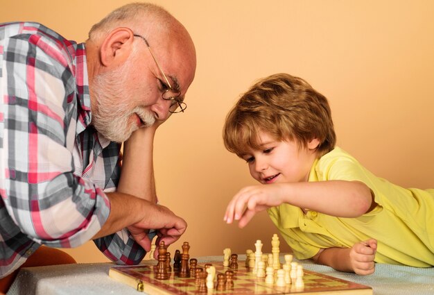 Niño niño desarrollando estrategia de ajedrez. Abuelo y nieto jugando al ajedrez. Concepto de lógica y desarrollo cerebral.