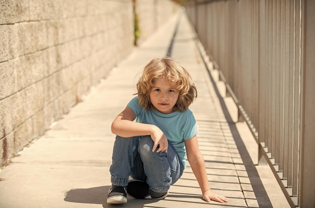 Niño niño descanse sentado en el paseo marítimo en verano descansando al aire libre