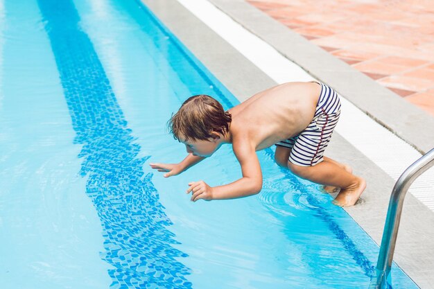 Niño niño feliz saltando en la piscina