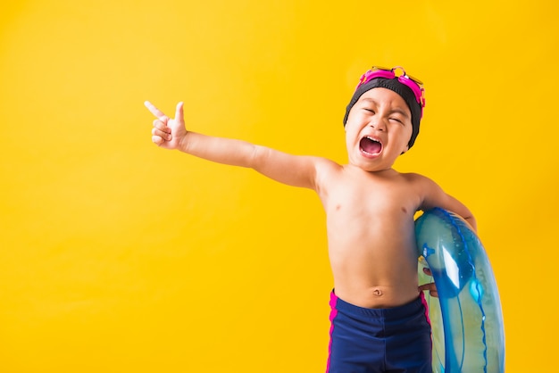 Niño niño con gafas y traje de baño con anillo inflable azul playa