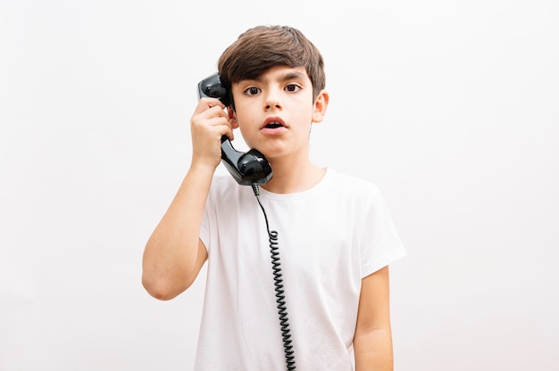 Niño niño hablando por teléfono vintage sorprendido