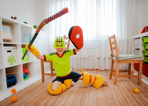 Un niño niño juega hockey en casa