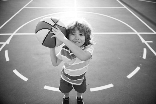 Niño niño jugando baloncesto con baloncesto