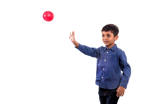 Niño niño jugando con pelota sobre fondo blanco.