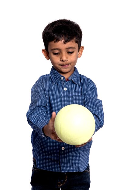 Niño niño jugando con pelota sobre fondo blanco.