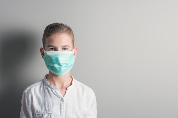 Niño un niño con una máscara médica sobre un fondo brillante