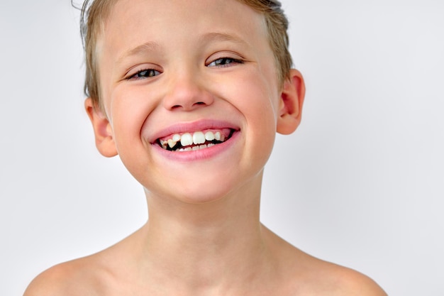 Niño niño mirando a cámara emocionado, con perfecta sonrisa con dientes, aislado en blanco