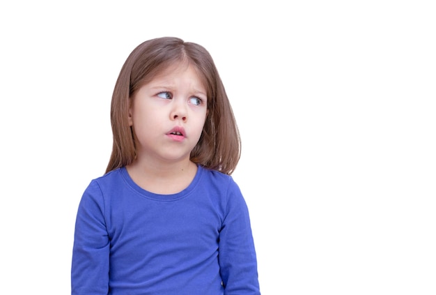 Niño niño mirando a un lado algo con desconfianza aislado sobre fondo blanco cintura para arriba niña caucásica de 5 años en azul