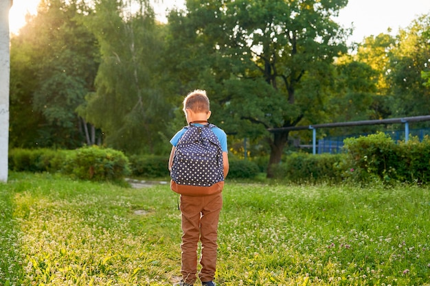 Niño va Niño con mochila en el primer día de escuela.