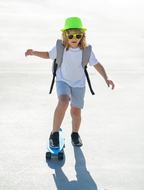 Niño niño montando patineta en la carretera niño practicando patineta los niños aprenden a andar en patineta