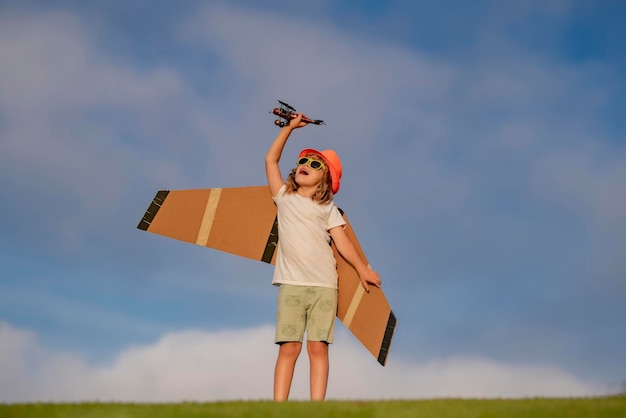 Niño niño niño pequeño jugando con avión de juguete y soñando con el futuro Piloto de niño feliz jugar con avión al aire libre