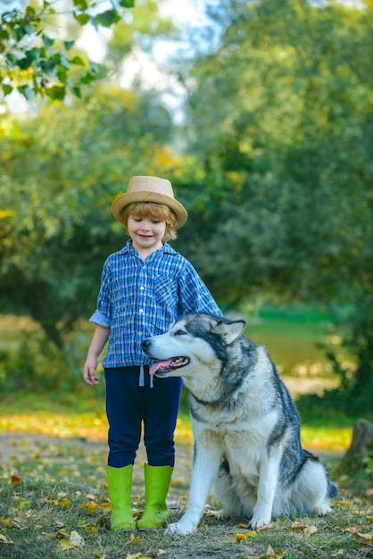 Niño niño y perro en el fondo de la naturaleza Concepto de aventura y vacaciones para niños Infancia despreocupada Paseo por la naturaleza con niños y mascotas Niños divertidos niño con perro