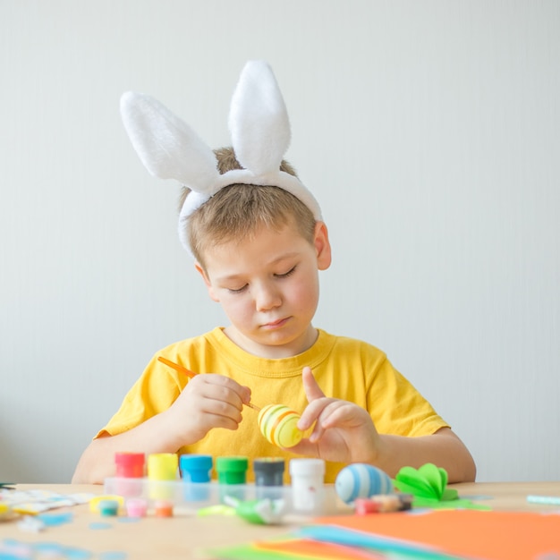 Niño niño pintado huevo de Pascua. Bricolaje para las vacaciones de semana santa con niños. Artesanía para la primavera