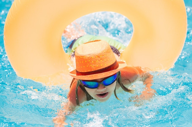 Niño niño en piscina con anillo de juguete inflable Niños nadar en vacaciones de verano Nadar para niños en flotador Playa mar y agua diversión