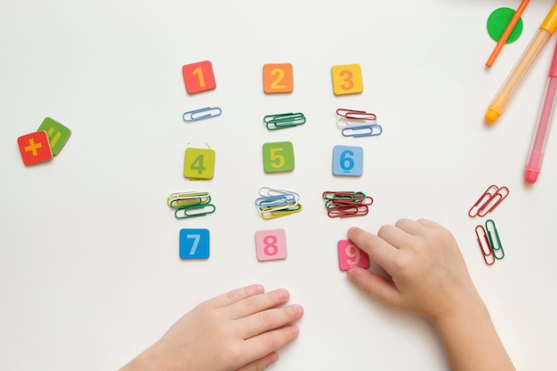 Niño niño preparándose para la escuela primaria haciendo ejercicios simples de Matemáticas.