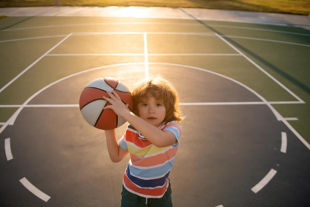 Niño niño preparándose para el tiro de baloncesto, el mejor deporte para niños, estilo de vida activo para niños