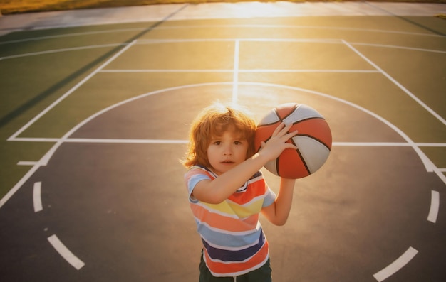 Niño niño preparándose para el tiro de baloncesto, el mejor deporte para niños, estilo de vida activo para niños