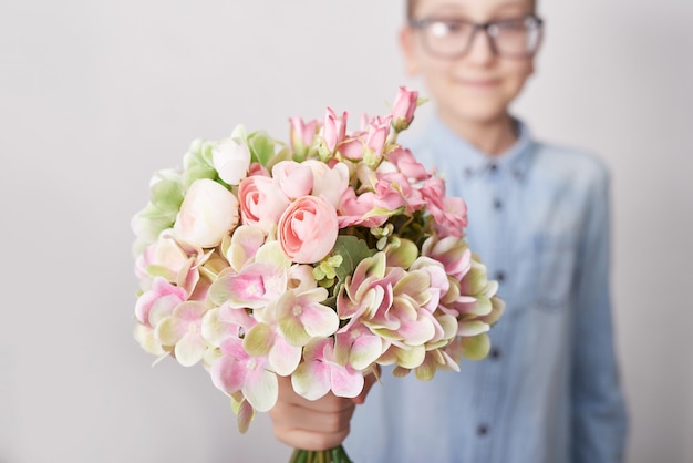 Niño niño con ramo de flores. Día de la Madre