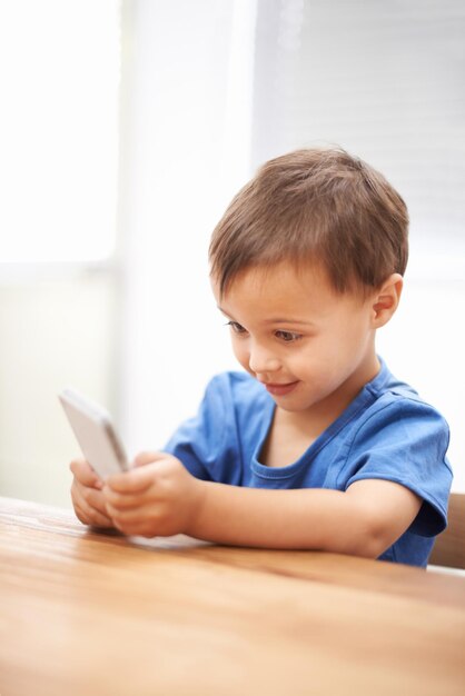 Niño niño y relajándose en el teléfono inteligente o conexión de mensajes de texto y jugando juegos en la tecnología Persona masculina hogar y aplicación móvil para redes sociales navegación en el sitio web y desplazamiento en internet