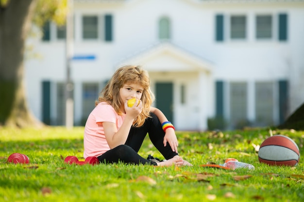 Foto niño niño relájese en la colchoneta deportiva después de ejercicios deportivos al aire libre en el parque estilo de vida saludable para niños