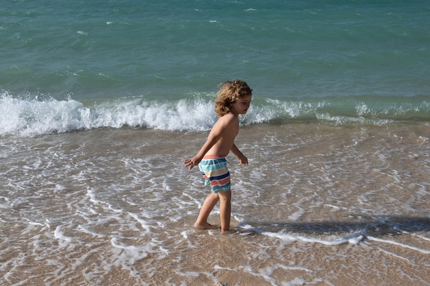 Niño niño saltando en las olas del mar saltando por agua mar salpicaduras verano niños vacaciones