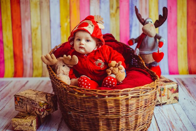 &quot;Niño niño en sudadera con capucha sentado en la cesta&quot;