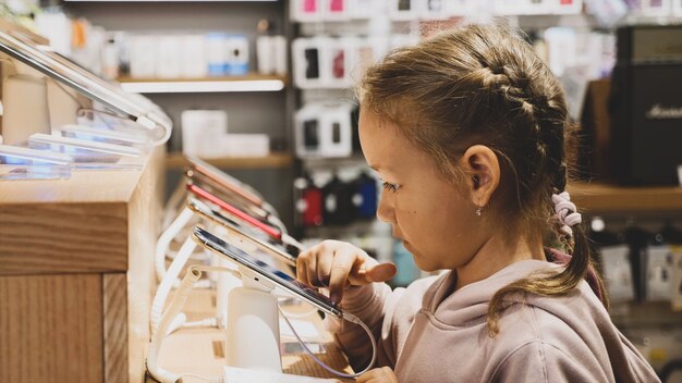 Niño con nuevo smartphone en mostrador en una tienda de electrónica.