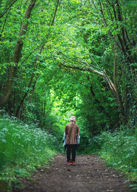 Un niño de ocho años en un bosque verde en primavera.