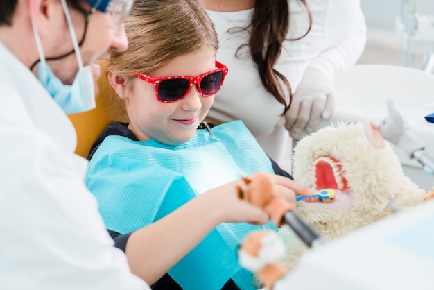 Niño en la oficina del dentista cuidando los dientes del juguete para mascotas