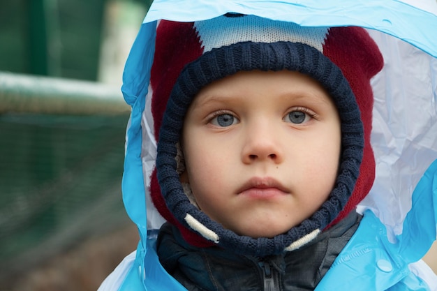 Niño de ojos azules en el impermeableRetrato de niño