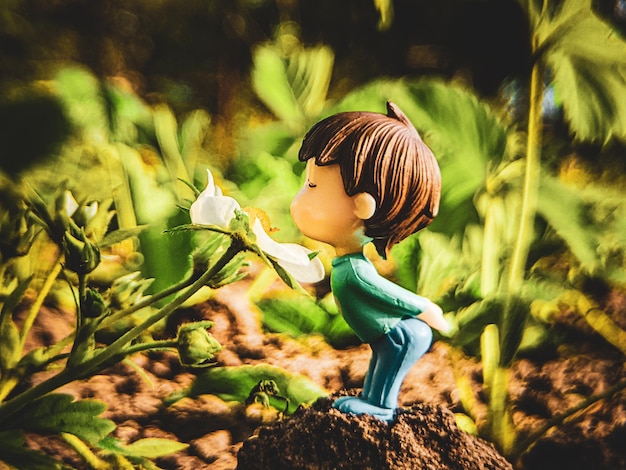 niño oliendo una flor