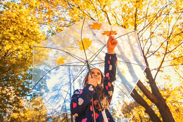 Niño de otoño en el parque con hojas amarillas Enfoque selectivo Niño