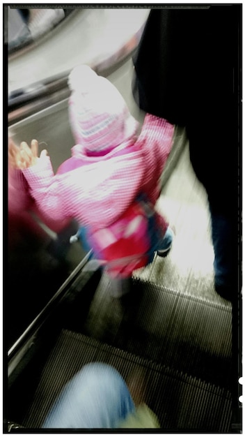 Foto niño con padre en escalera mecánica