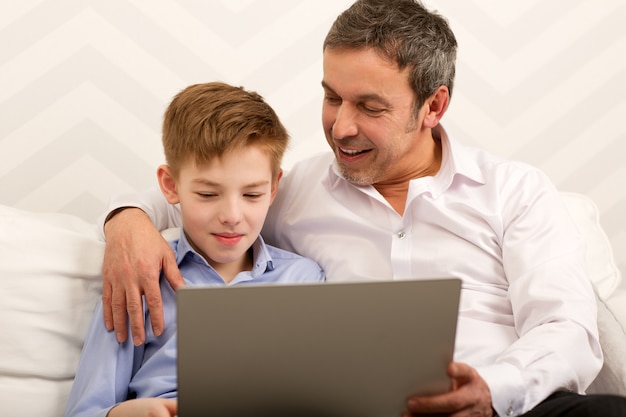 Niño y padre usando laptop juntos