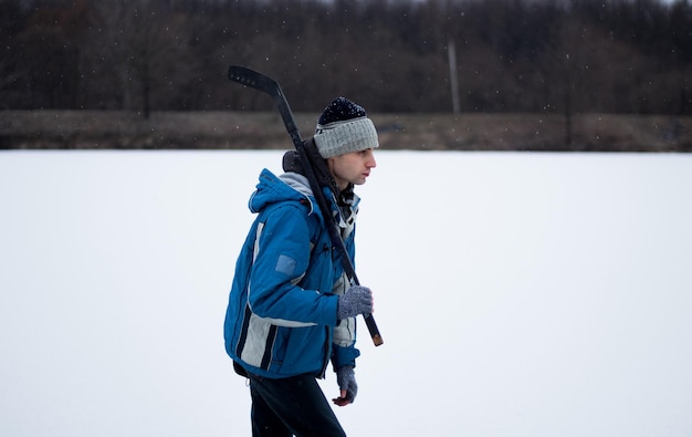 un niño con un palo de hockey en invierno