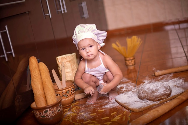 niño con pan en las manos vestido de cocinero