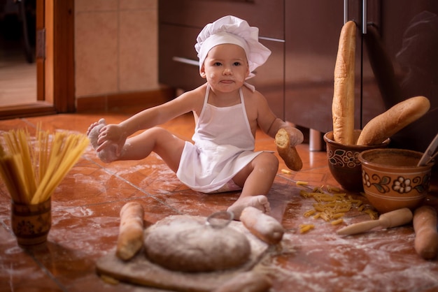 niño con pan en las manos vestido de cocinero