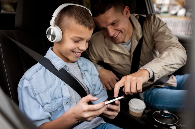 Niño y papá cerca de un coche eléctrico.