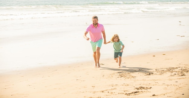 Niño y papá corriendo en la playa en vacaciones de verano juntos vacaciones