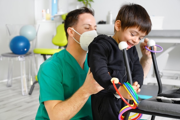 Foto niño con parálisis cerebral en fisioterapia en un centro de terapia infantil.