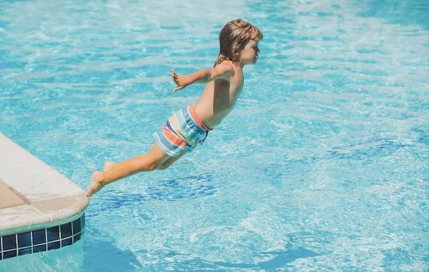 Niño en el parque acuático niño saltando al agua en las vacaciones de verano nadando en el campamento de verano