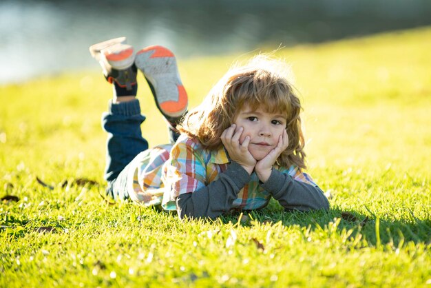 Niño en el parque al aire libre primavera niño acostado sobre la hierba verano niño caminar niños adaptación