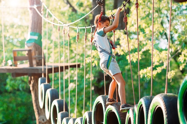 Un niño pasa el obstáculo en el parque de cuerdas.