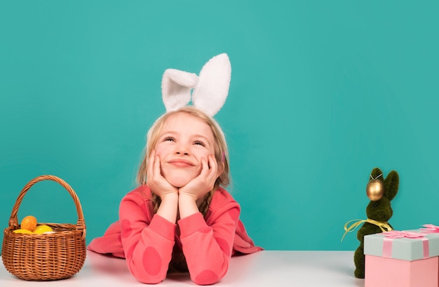 Niño de Pascua niña divertida con orejas de conejo y divirtiéndose con huevos de Pascua copia divertida de los niños conejitos