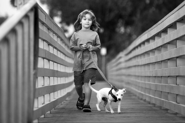 Niño paseando a un perro al aire libre con su amiga mascota