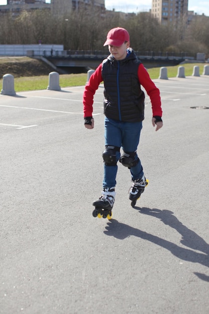 Foto niño patinando en línea en el estacionamiento de la ciudad