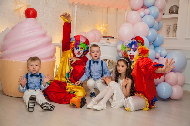 Niño payaso con niña payaso divirtiéndose en unas vacaciones con niños