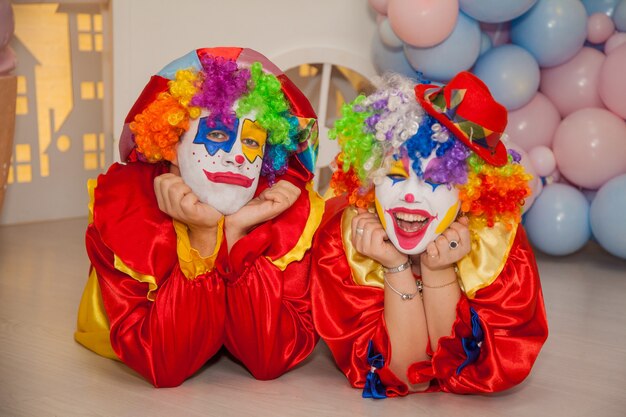 Niño payaso con niña payaso divirtiéndose en las vacaciones